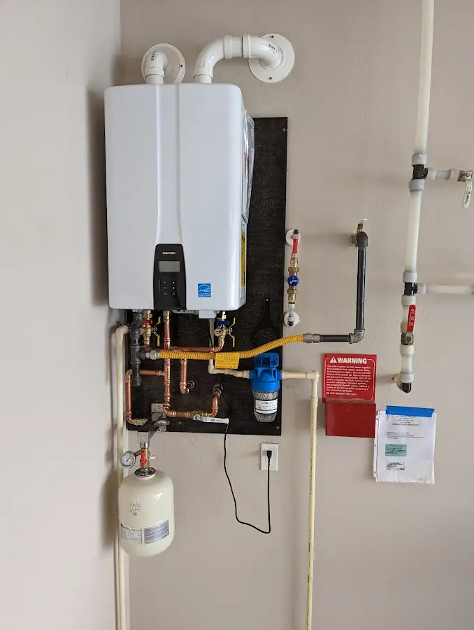 Professional plumber installing copper piping in a DeWitt home